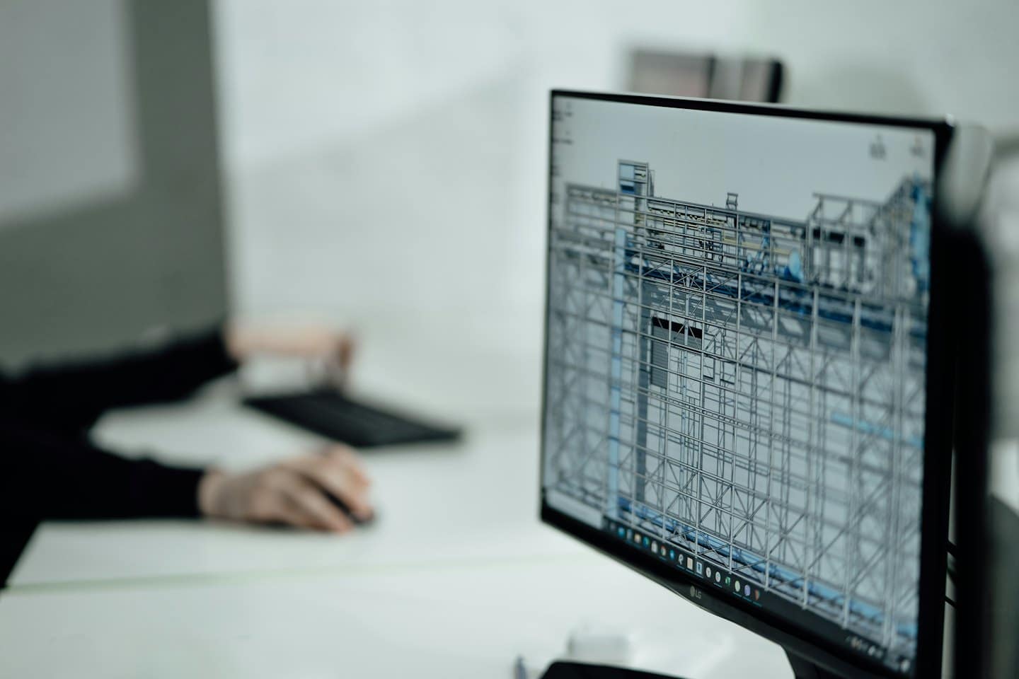 Na monitore počítača sa zobrazuje 3D drôtený model s rukami na klávesnici.